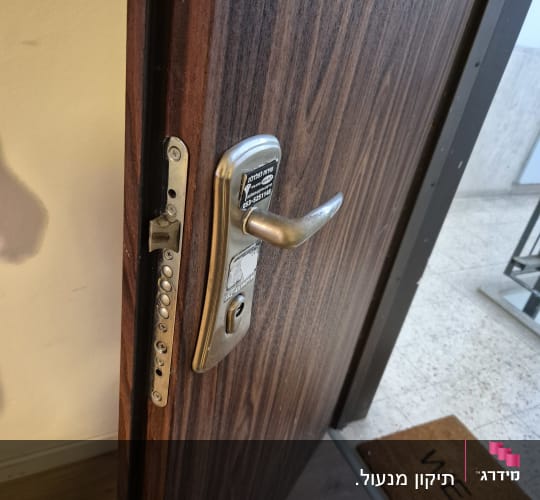 מנעול דלת עם ידית ומספר טלפון על המדבקה